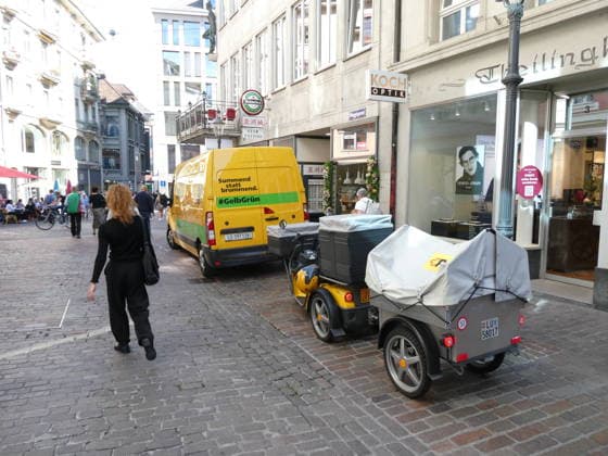 29.09.2026 Schweiz. Bild . Postzustellung mit Lieferwagen 100 Prozent Electric und ein elektrischen Dreiradroller.