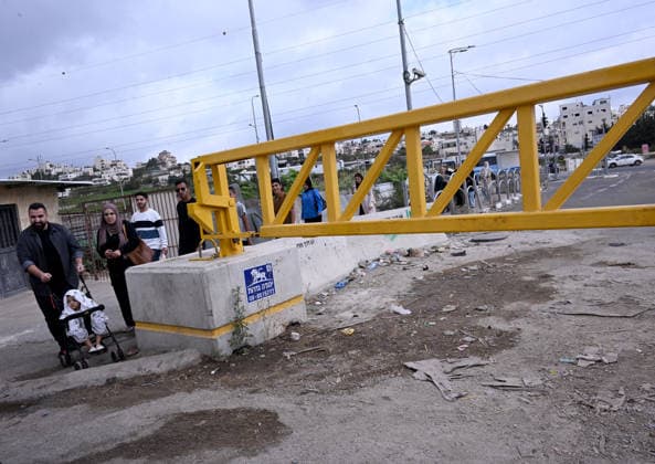 Palestinians walk past an Israeli erected locked gate that blocks cars from moving to and from the village of Khirbat Zayta, near Hebron in the West Bank, on Tuesday, September 29, 2026. Israel declared a West Bank military closure to restrict Palestinian movement during the Jewish holiday of Sukkot from September 27 - October 3, 2026.  JER2026092905 DEBBIExHILL