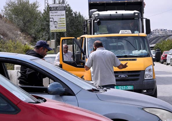 Palestinians stand by their cars behind an Israeli erected locked gate that blocks cars from moving to and from the village of Halhul, near Hebron in the West Bank, on Tuesday, September 29, 2026. Israel declared a West Bank military closure to restrict Palestinian movement during the Jewish holiday of Sukkot from September 27 - October 3, 2026.  JER2026092911 DEBBIExHILL