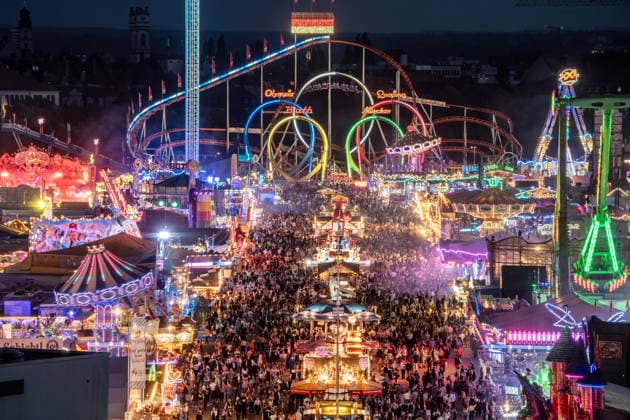 Überblick von der St. Paul Kirche aus 50 Metern Höhe auf das Lichtermeer der abendlichen Wiesn, das Oktoberfest leuchtet in allen Farben, bestes Wiesnwetter, München, 30. September 2026 Deutschland, München, 30. September 2026, Überblick von der St. Paul Kirche aus 50 Metern Höhe auf das Lichtermeer der abendlichen Wiesn, das Oktoberfest leuchtet in allen Farben, tausende Wiesenbesucher strömen abends um 19:15 Uhr über die Schaustellerstraße mit ihren Fahrgeschäften, den Abschluss bildet der Olympia-Looping, Festgelände, bestes Wiesnwetter am Mittwochabend, typisch bayerisch, Volksfest, Bayern,