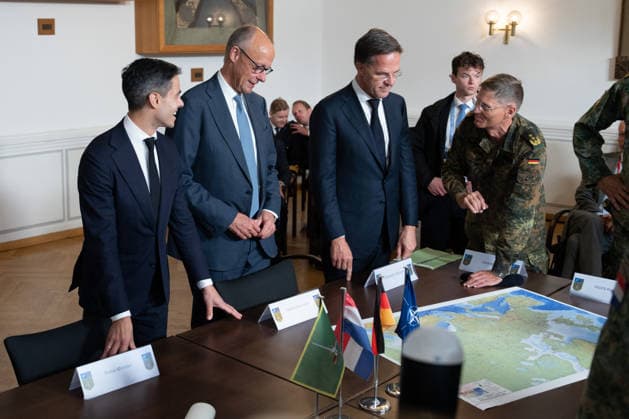 Besuch des Deutsch-Niederlaendischen Corps mit Bundeskanzler Merz Rob Jetten, Premierminister Niederlande gemeinsam mit Bundeskanzler Friedrich Merz, NATO Generalsekretaer Mark Ruette hoeren gespannt den Erlaeuterungen Generalleutnant Peter Mirow zu, der eine europaeische Karte beim Besuch des 1. Deutsch-Niederlaendische Corps, Muenster, 01.10.2026 Muenster NRW Deutschland