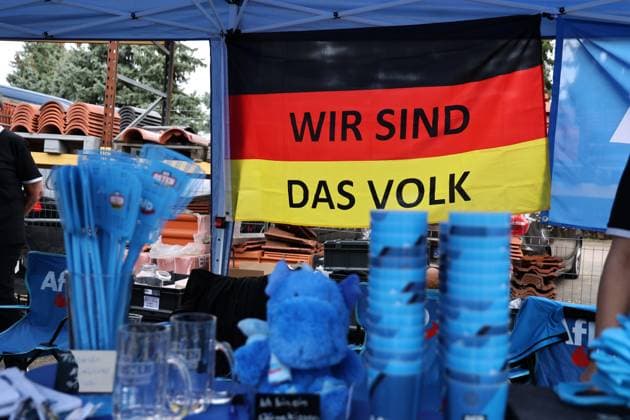 Auf eine Bratwurst mit Haseloff und Chrupalla 01.10.2026, Doellstaedt, Veranstaltung der AfD bei Kiesling Bedachungen, Auf eine Bratwurst mit Landtagsabgeordneten Daniel Haseloff (AfD) und AfD Bundessprecher Tino Chrupalla im Bild: Merchandise-Produkte der AfD an einem Verkaufsstand vom AfD Fanshop, hier eine Deutschlandfahne mit der Aufschrift Wir sind das Volk, Fliegenklatschen, Becher und Plueschtiere