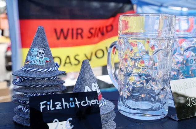 Auf eine Bratwurst mit Haseloff und Chrupalla 01.10.2026, Doellstaedt, Veranstaltung der AfD bei Kiesling Bedachungen, Auf eine Bratwurst mit Landtagsabgeordneten Daniel Haseloff (AfD) und AfD Bundessprecher Tino Chrupalla im Bild: Merchandise-Produkte der AfD an einem Verkaufsstand vom AfD Fanshop, hier Filzhuetchen mit dem Konterfei von Bjoern Hoecke mit Sonnenbrille und der Aufschrift team Hoecke, daneben Bierkruege