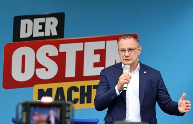 Auf eine Bratwurst mit Haseloff und Chrupalla 01.10.2026, Doellstaedt, Veranstaltung der AfD bei Kiesling Bedachungen, Auf eine Bratwurst mit Landtagsabgeordneten Daniel Haseloff (AfD) und AfD Bundessprecher Tino Chrupalla im Bild: Tino Chrupalla haelt eine Rede auf der Buehne, im Hintergrund der Satz Der Osten machts
