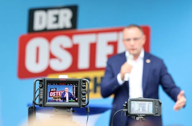 Auf eine Bratwurst mit Haseloff und Chrupalla 01.10.2026, Doellstaedt, Veranstaltung der AfD bei Kiesling Bedachungen, Auf eine Bratwurst mit Landtagsabgeordneten Daniel Haseloff (AfD) und AfD Bundessprecher Tino Chrupalla im Bild: Tino Chrupalla haelt eine Rede auf der Buehne, im Hintergrund der Satz Der Osten machts