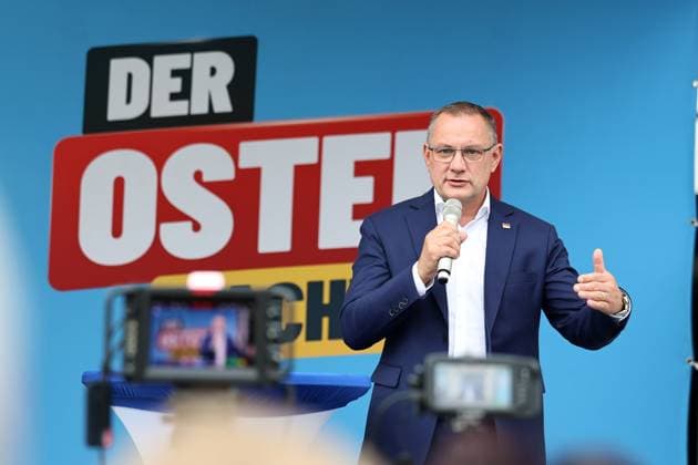 Auf eine Bratwurst mit Haseloff und Chrupalla 01.10.2026, Doellstaedt, Veranstaltung der AfD bei Kiesling Bedachungen, Auf eine Bratwurst mit Landtagsabgeordneten Daniel Haseloff (AfD) und AfD Bundessprecher Tino Chrupalla im Bild: Tino Chrupalla haelt eine Rede auf der Buehne, im Hintergrund der Satz Der Osten machts