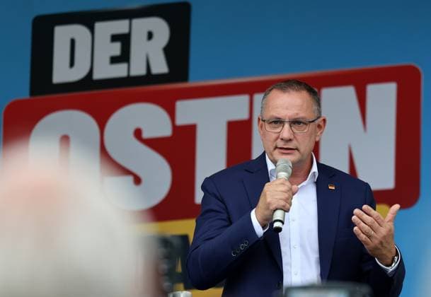 Auf eine Bratwurst mit Haseloff und Chrupalla 01.10.2026, Doellstaedt, Veranstaltung der AfD bei Kiesling Bedachungen, Auf eine Bratwurst mit Landtagsabgeordneten Daniel Haseloff (AfD) und AfD Bundessprecher Tino Chrupalla im Bild: Tino Chrupalla haelt eine Rede auf der Buehne, im Hintergrund steht der Satz Der Osten machts