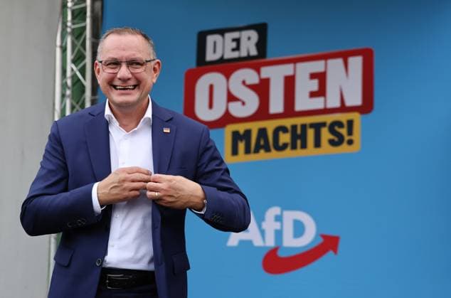 Auf eine Bratwurst mit Haseloff und Chrupalla 01.10.2026, Doellstaedt, Veranstaltung der AfD bei Kiesling Bedachungen, Auf eine Bratwurst mit Landtagsabgeordneten Daniel Haseloff (AfD) und AfD Bundessprecher Tino Chrupalla im Bild: Tino Chrupalla, im Hintergrund steht der Satz Der Osten machts