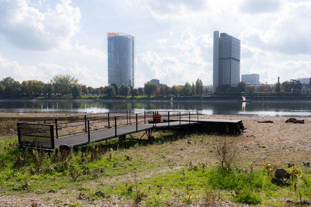 Niedrigwasser am Rhein in Bonn - 02.10.26 Nach den jüngsten Regenfällen steigt der Pegel Bonn wieder leicht an und liegt bei 64 cm nur wenig über dem Rekordtief von 58 cm vom 29. September. Am Beueler Rheinufer liegt der alte Bootsslip der DLRG Bonn trocken, auch der nahegelegene Bootssteg der DLRG ist vom Niedrigwasser betroffen. Im Hintergrund die Bonner Skyline mit Post Tower, Langer Eugen. Bonn Beuel Nordrhein-Westfalen Deutschland Copyright: xMarcxJohnx