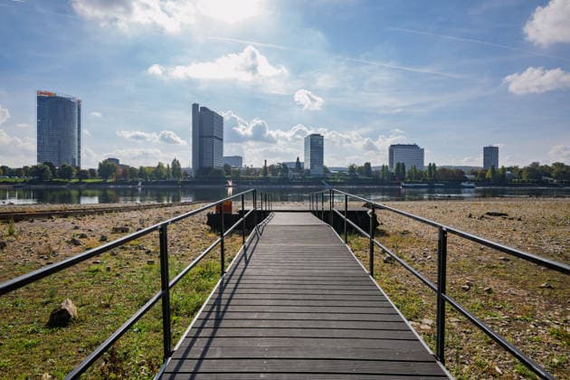 Niedrigwasser am Rhein in Bonn - 02.10.26 Nach den jüngsten Regenfällen steigt der Pegel Bonn wieder leicht an und liegt bei 64 cm nur wenig über dem Rekordtief von 58 cm vom 29. September. Am Beueler Rheinufer liegt der alte Bootsslip der DLRG Bonn trocken, auch der nahegelegene Bootssteg der DLRG ist vom Niedrigwasser betroffen. Im Hintergrund die Bonner Skyline mit Post Tower, Langer Eugen, Climate Tower (UN Campus), Radisson Blu Hotel am WCCB und dem Hochhaus Stadtquartier Neuer Kanzlerplatz. Bonn Beuel Nordrhein-Westfalen Deutschland Copyright: xMarcxJohnx