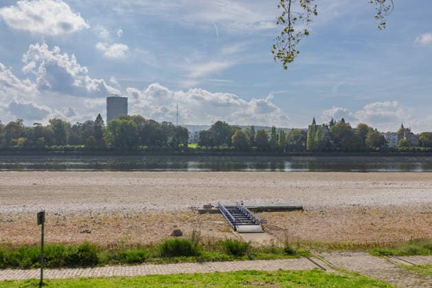 Niedrigwasser am Rhein in Bonn: Blick vom Beueler Ufer - 02.10.26 Blick vom Beueler Rheinufer auf das durch die anhaltende Niedrigwasserlage größtenteils trockenliegende Flussbett des Rheins in Bonn. Die Schifffahrt ist eingeschränkt, der Pegel Bonn liegt bei 64 cm und damit nur wenig über dem Rekordtief von 58 cm vom 29. September. Freiliegender Bootssteg. Im Hintergrund die Villa Hammeschmidt Bonn Beuel Nordrhein-Westfalen Deutschland Copyright: xMarcxJohnx
