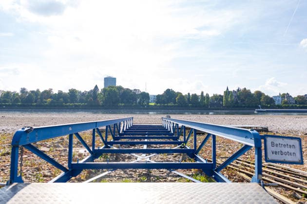 Niedrigwasser am Rhein in Bonn: Blick vom Beueler Ufer - 02.10.26 Blick vom Beueler Rheinufer auf das durch die anhaltende Niedrigwasserlage größtenteils trockenliegende Flussbett des Rheins in Bonn. Die Schifffahrt ist eingeschränkt, der Pegel Bonn liegt bei 64 cm und damit nur wenig über dem Rekordtief von 58 cm vom 29. September. Freiliegender Bootssteg. Im Hintergrund die Villa Hammeschmidt. Vorbeiziehendes Ruderboot Bonn Beuel Nordrhein-Westfalen Deutschland Copyright: xMarcxJohnx