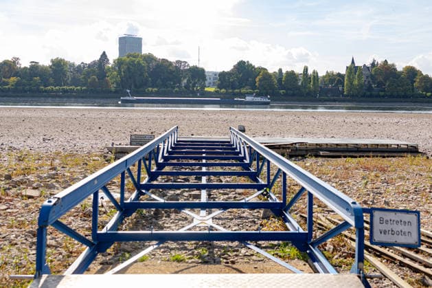 Niedrigwasser am Rhein in Bonn: Blick vom Beueler Ufer - 02.10.26 Blick vom Beueler Rheinufer auf das durch die anhaltende Niedrigwasserlage größtenteils trockenliegende Flussbett des Rheins in Bonn. Die Schifffahrt ist eingeschränkt, der Pegel Bonn liegt bei 64 cm und damit nur wenig über dem Rekordtief von 58 cm vom 29. September. Freiliegender Bootssteg. Im Hintergrund die Villa Hammeschmidt. Vorbeiziehendes Frachtschiff Bonn Beuel Nordrhein-Westfalen Deutschland Copyright: xMarcxJohnx