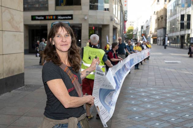 03.10.2026 Pressetermin Initiative Es brennt Menschenkette in Dortmund, Hansaplatz Sylvia Jost unterstützt xr und führt das Banner an Dortmund Hansaplatz und Westenhellweg NRW Deutschland