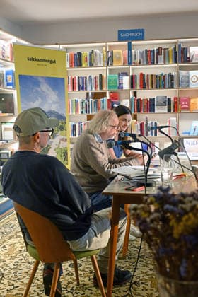 Minifestival AH0J (Literaturfestival) - Tschechien setzt über - der Kulturinitiative Literaturschiff, in der Buchhandlung Kurdirektion in Bad Ischl. Lesungen und Gespräche in Korrespondenz zum Gastauftritt Tschechiens auf der Frankfurter Buchmesse 2026. Es liest die tschechische Schriftstellerin Anna Bloch-Stickova. Die Veranstaltung wird moderiert von Michael Stavaric, fotografiert am 02.10.26. Das Bild zeigt v.l.n.r.< Moderator Michael Stavaric (StavariÄ), den Schriftsteller Michal Ajvaz mit der Konsekutivbersetzerin Lena Kurz. 2026 - Minifestival AH0J (Literaturfestival) - Tschechien setzt über - der Kulturinitiative Literaturschiff, in der Buchhandlung Kurdirektion in Bad Ischl. Lesungen und Gespräche in Korrespondenz zum Gastauft
