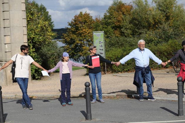 Demonstranten während einer Menschenkette für Klimaschutz und Demokratie auf der Glienicker Brücke in Potsdam, 3. Oktober 2026. Es brennt! Menschenkette Potsdam