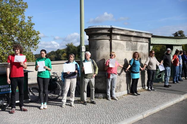 Demonstranten während einer Menschenkette für Klimaschutz und Demokratie auf der Glienicker Brücke in Potsdam, 3. Oktober 2026. Es brennt! Menschenkette Potsdam