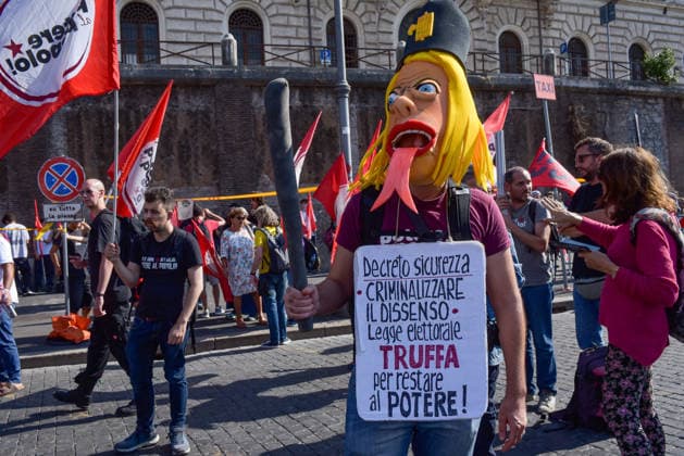 October 3, 2026, Rome, Rome, Italy: A demonstrator wearing a mask representing Prime Minister Giorgia Meloni with a headpiece featuring a fascist symbol during the Potere al Popolo demonstration at Piazza Bocca della VeritÃ in Rome on October 3, 2026. Rome Italy - ZUMAn299 20261003_zip_n299_003 Copyright: xVincenzoxNuzzolesex
