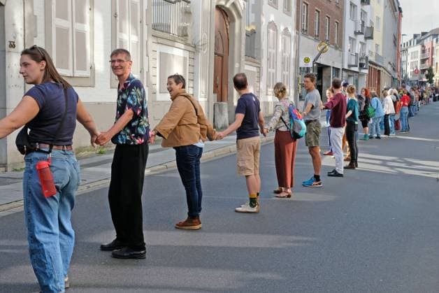 Es brennt! Menschenkette. Aachen, 03.10.2026: Menschenkette der bundesweiten Aktion Es brennt! Die Aachener Menschenkette soll vom Domhof durch die Innenstadt bis nach Kelmis, Belgien reichen. Nach Schätzungen beteiligten sich etwa 3000 Menschen aus verschiedenen Organisationen und Parteien. Aachen Jakobstraße NRW Deutschland
