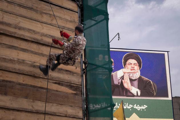 Opening Ceremony Of Second City-Square Military Training Camp An armed Iranian Army serviceman stands next to a portrait of the late Hezbollah Secretary-General Hassan Nasrallah during the opening ceremony of the second city-square military training camp for self-sacrificing forces in downtown Tehran, Iran, on October 3, 2026. The camp was established by the Basij paramilitary force, with personnel from the Islamic Republic of Iran Army responsible for training the volunteers. Tehran Tehran Iran  Copyright: xMortezaxNikoubazlx originalFilename: nikoubazl-openingc261003_np5Y6.jpg