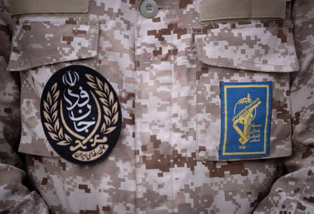 Opening Ceremony Of Second City-Square Military Training Camp A member of the Islamic Revolutionary Guard Corps (IRGC) attaches a badge for self-sacrificing forces to his uniform while standing guard during the opening ceremony of the second city-square military training camp in downtown Tehran, Iran, on October 3, 2026. The camp was established by the Basij paramilitary force, with personnel from the Islamic Republic of Iran Army responsible for training the volunteers. Tehran Tehran Iran  Copyright: xMortezaxNikoubazlx originalFilename: nikoubazl-openingc261003_npNZd.jpg