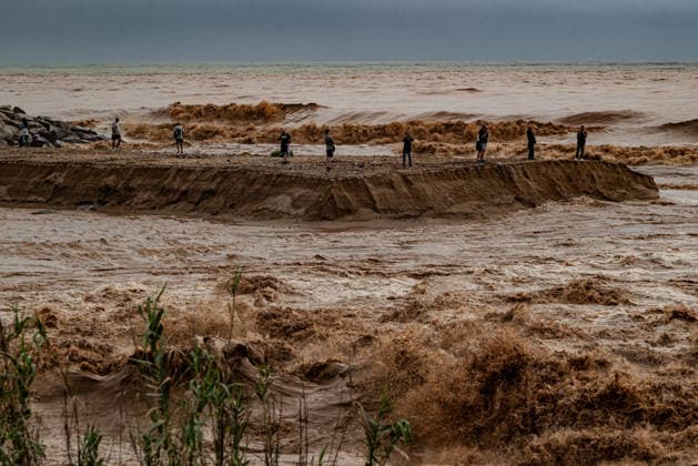 October 4, 2026, Sant Adria Del Besos, Barcelona, Spain: People stays at the mouth of the Besos River, north of Barcelona, swollen and laden with sediment after a night of torrential rain across Catalonia. The storm brought exceptional rainfall to the Barcelona metropolitan area, with more than 200 litres per square metre recorded in parts of the region. The Besos rose sharply overnight, prompting authorities to warn of an imminent risk of flooding. Sant Adria Del Besos Spain  - ZUMAb137 20261004_fap_b137_002 Copyright: xJordixBoixareux