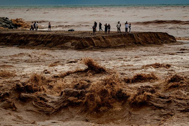 October 4, 2026, Sant Adria Del Besos, Barcelona, Spain: People stays at the mouth of the Besos River, north of Barcelona, swollen and laden with sediment after a night of torrential rain across Catalonia. The storm brought exceptional rainfall to the Barcelona metropolitan area, with more than 200 litres per square metre recorded in parts of the region. The Besos rose sharply overnight, prompting authorities to warn of an imminent risk of flooding. Sant Adria Del Besos Spain  - ZUMAb137 20261004_fap_b137_006 Copyright: xJordixBoixareux
