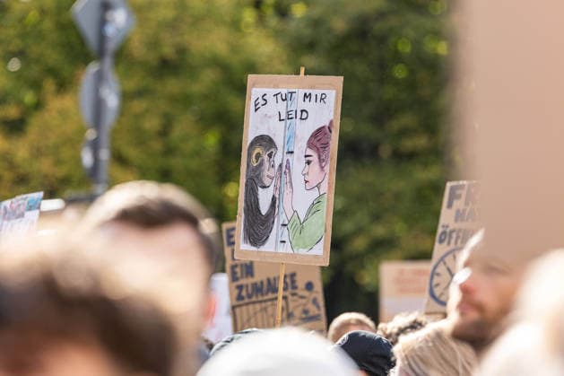 Robert Marc Lehmann bei Anti-Zoo-Demonstration in Berlin Berlin, Deutschland, 04.10.2026: Ein selbst gestaltetes Protestplakat mit der Aufschrift Es tut mir leid zeigt bei der F*CK ZOOS-Demonstration eine gezeichnete Szene zwischen einem Menschen und einem Affen. Im Hintergrund sind weitere Demonstrierende und Plakate zu sehen. Berlin Deutschland Berlin