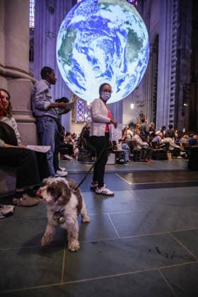 October 4, 2026, New York, New York, United States: A dog with its owner beneath Gaia, the monumental illuminated Earth installation by British artist LUKE JERRAM, during the Blessing of the Earth and Animals at the Cathedral of St. John the Divine in New York. The annual St. Francis Day celebration brings animals and their human companio New York United States - ZUMAo116 20261004_znp_o116_022 Copyright: xBiancaxOterox