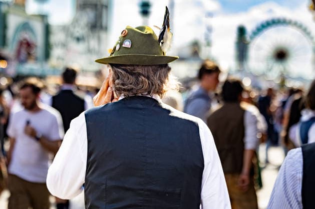 Oktoberfest 2026 in München 04.10.2026: Ein Mann in traditioneller Tracht und Trachtenhut inmitten der Besucher auf dem Festgelände. Er hält telefonierend seine linke Hand am Ohr. Das 191. Oktoberfest fand 2026 vom 19. September bis 4. Oktober auf der Theresienwiese statt. Das Münchner Oktoberfest zählt zu den größten Volksfesten der Welt und zieht jährlich Millionen Besucher aus Deutschland und dem Ausland an. Muenchen Theresienwiese Bayern Deutschland