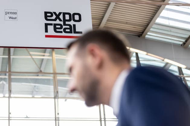 EXPO REAL 2026 in München 05.10.2026: Fachbesucher auf dem Weg in die Messehallen auf dem Gelände Messe München. Erster Messetag der EXPO REAL 2026. Die internationale Fachmesse für Immobilien, Investitionen und Infrastruktur findet vom 5. bis 7. Oktober 2026 in München statt und bringt Vertreter der Immobilienwirtschaft, Investoren, Projektentwickler, Finanzierer sowie weitere Akteure der Branche zusammen. Muenchen Messe Bayern Deutschland