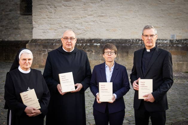 Sr. Maria Cordis Reiker, Generaloberin der Thuiner Franziskanerinnen (v.l.n.r.), Bischof Dominicus Meier, Bischof von Osnabrueck (Osnabrück), Beate Gilles, Generalsekretaerin der Deutschen Bischofskonferenz, und Bischof Heiner Wilmer, Bischof von Muenster (Münster) und Vorsitzender der katholischen Deutschen Bischofskonferenz, halten waehrend eines Gruppenfotos die Studie Macht durch Charisma. Geistlicher Missbrauch in Geistlichen Gemeinschaften der Muensteraner Theologen Judith Koenemann und Bernhard Frings, am Rande einer Pressekonferenz der Bistuemer Muenster (Münster) und Osnabrueck (Osnabrück) sowie der Deutschen Bischofskonferenz und Thuiner Franziskanerinnen am 5. Oktober 2026 in Muenster (Münster) (Foto vom 05.10.2026). (Sieh Copyright: epd-bild DetlefxHeese epd-Missbrauch-MS-1596