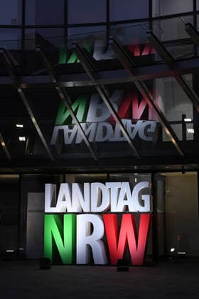 Start der Illumination zur Woche der Demokratie und zur Parlamentsnacht am 05.10.2026 auf dem Vorplatz des Landtags Nordrhein-Westfalen in Düsseldorf Der Landtag Nordrhein-Westfalen feiert sein 80-jähriges Bestehen mit einer Woche der Demokratie: Vom 5. bis zum 11. Oktober 2026 wird das Parlamentsgebäude am Rhein zur Leinwand für die Lichtinszenierung -Fundament der Demokratie-. Die Illumination hat das Künstlerduo Hartung & Trenz konzipiert. Die Illumination ist in den Landesfarben rot, grün und weiß gehalten. Andre Kuper, Präsident des Landtags, startet sie am Montag, 5. Oktober, um 19.30 Uhr. Ab dann ist sie bis Sonntag, 11. Oktober 2026, in der Zeit von ca. 19.30 Uhr bis 23 Uhr jeden Abend zu sehen.