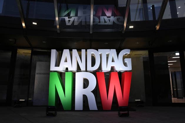 Start der Illumination zur Woche der Demokratie und zur Parlamentsnacht am 05.10.2026 auf dem Vorplatz des Landtags Nordrhein-Westfalen in Düsseldorf Der Landtag Nordrhein-Westfalen feiert sein 80-jähriges Bestehen mit einer Woche der Demokratie: Vom 5. bis zum 11. Oktober 2026 wird das Parlamentsgebäude am Rhein zur Leinwand für die Lichtinszenierung -Fundament der Demokratie-. Die Illumination hat das Künstlerduo Hartung & Trenz konzipiert. Die Illumination ist in den Landesfarben rot, grün und weiß gehalten. Andre Kuper, Präsident des Landtags, startet sie am Montag, 5. Oktober, um 19.30 Uhr. Ab dann ist sie bis Sonntag, 11. Oktober 2026, in der Zeit von ca. 19.30 Uhr bis 23 Uhr jeden Abend zu sehen.