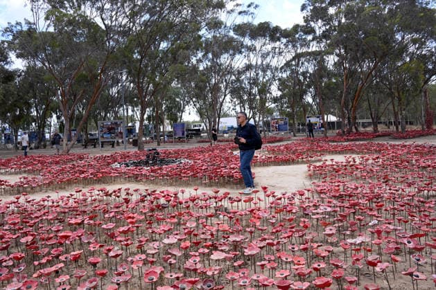 A man walks in an installation of red poppies in memorial to the victims killed by Hamas on October 7, 2023, at the Nova Festival Memorial site in Re im, near the Gaza border on Monday, October 6, 2026. Israel is marking three years since the Hamas attack that killed 1,200 people and 251 were taken hostage into Gaza.  JER2026100605 DEBBIExHILL