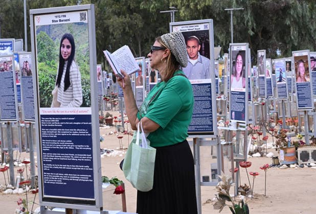 An Israeli woman prays near photos of victims killed by Hamas on October 7, 2023, at the Nova Festival Memorial site in Re im, near the Gaza border on Monday, October 6, 2026. Israel is marking three years since the Hamas attack that killed 1,200 people and 251 were taken hostage into Gaza.  JER2026100609 DEBBIExHILL