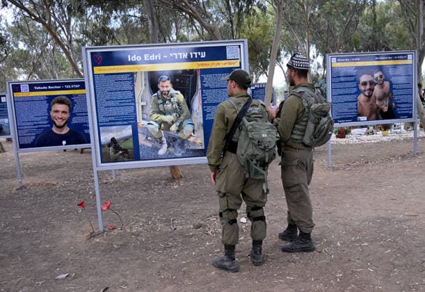 Israeli soldiers look at photos of victims killed by Hamas on October 7, 2023, at the Nova Festival Memorial site in Re im, near the Gaza border on Monday, October 6, 2026. Israel is marking three years since the Hamas attack that killed 1,200 people and 251 were taken hostage into Gaza.  JER2026100606 DEBBIExHILL