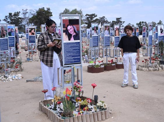 An Israeli woman prays in front of a photo of a victim killed by Hamas on October 7, 2023, at the Nova Festival Memorial site in Re im, near the Gaza border on Monday, October 6, 2026. Israel is marking three years since the Hamas attack that killed 1,200 people and 251 were taken hostage into Gaza.  JER2026100619 DEBBIExHILL