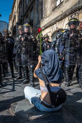 October 6, 2026, Bordeaux, Nouvelle-Aquitaine, France: Seated on the ground in front of mobile gendarmes, a young high school student offers them a rose during the demonstration in Bordeaux on October 6, 2026. Bordeaux France - ZUMAh207 20261006_zip_h207_001 Copyright: xFabricexHebertx