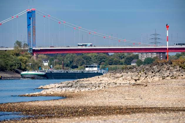 Extremes Niedrigwasser am Rhein, hier bei Duisburg-Neuenkamp, trocken gefallenes Ufer, Pegel zur Zeit der Aufnahme bei 131cm in DU-Ruhrort, über 20cm unter der bisherigen je gemessnen Tiefstmarke von 2018, starke Einschränkungen für die Binnenschifffahrt, im Hintergrund die Friedrich-Eber-Brücke über den Rhein bei DU-Ruhrort, , NRW, Deutschland Rhein Niedrigwasser