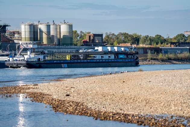 Extremes Niedrigwasser am Rhein, hier bei Duisburg-Neuenkamp, trocken gefallenes Ufer, Pegel zur Zeit der Aufnahme bei 131cm in DU-Ruhrort, über 20cm unter der bisherigen je gemessnen Tiefstmarke von 2018, starke Einschränkungen für die Binnenschifffahrt, im Hintergrund das Sachtleben Chemie International Werk, NRW, Deutschland Rhein Niedrigwasser
