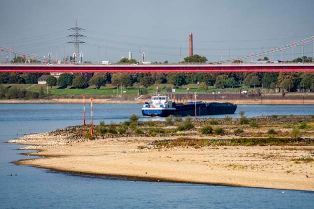 Extremes Niedrigwasser am Rhein, hier bei Duisburg-Ruhrort, trocken gefallenes Ufer, Pegel zur Zeit der Aufnahme bei 131cm in DU-Ruhrort, über 20cm unter der bisherigen je gemessnen Tiefstmarke von 2018, starke Einschränkungen für die Binnenschifffahrt, im Hintergrund die Friedrich-Eber-Brücke über den Rhein bei DU-Ruhrort,NRW, Deutschland Rhein Niedrigwasser