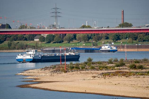 Extremes Niedrigwasser am Rhein, hier bei Duisburg-Ruhrort, trocken gefallenes Ufer, Pegel zur Zeit der Aufnahme bei 131cm in DU-Ruhrort, über 20cm unter der bisherigen je gemessnen Tiefstmarke von 2018, starke Einschränkungen für die Binnenschifffahrt, im Hintergrund die Friedrich-Eber-Brücke über den Rhein bei DU-Ruhrort,NRW, Deutschland Rhein Niedrigwasser