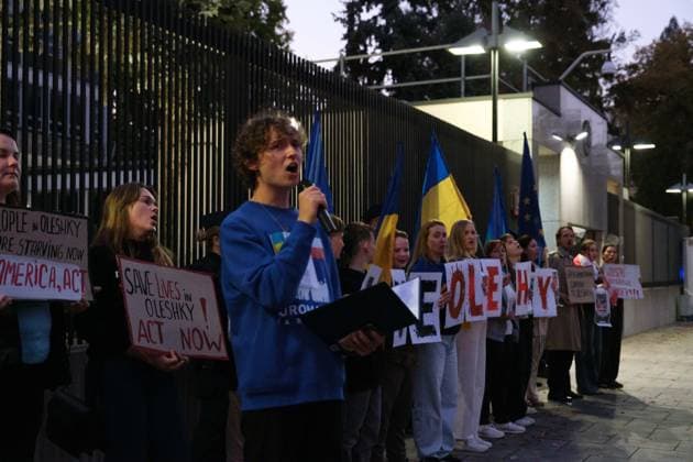 October 6, 2026, Warsaw, Masovian Voivodeship, Poland: A protester speaks as others hold placards calling for international humanitarian action during a demonstration outside the US Embassy in Warsaw protesting the humanitarian crisis in Russian-occupied Oleshky. The protest was organized by Poland s Ukrainian diaspora as an appeal to Ukraine s international partners to step up diplomatic efforts to support civilians trapped in Oleshky with humanitarian aid and the possibility of evacuation. Warsaw Poland  - ZUMAk204 20261006_zip_k204_017 Copyright: xRomanxKozielx