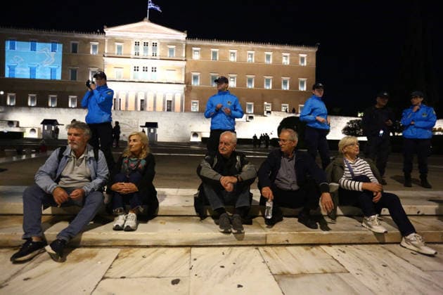 October 6, 2026, Athens, Attica, GREECE: Demonstrators sit on steps in front of the Greek Parliament on Syntagma Square, as police officers stand behind them during an anti-war protest opposing the visit of US Secretary of State MARCO RUBIO. Athens GREECE - ZUMAx103 20261006_zip_x103_012 Copyright: xHarrisxXanthopoulosx