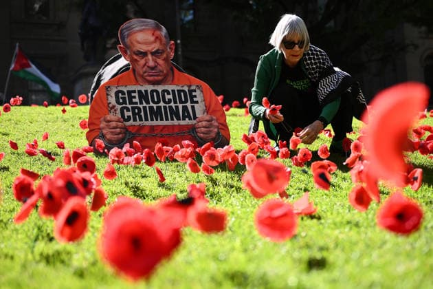 PRO-PALESTINE VIGIL, A pro-Palestine protestor places poppies on the lawn around a placard featuring Israel Prime Minister Benjamin Netanyahu during a vigil for Gaza at the State Library Victoria in Melbourne, Wednesday, October 7, 2026. ( NO ARCHIVING MELBOURNE VICTORIA Australia  Copyright: xJOELxCARRETTx 20261007174550677190