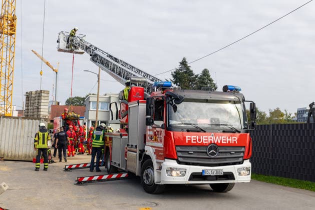 RECORD DATE NOT STATED Feuerwehr und Rettungsdienst versorgen eine Person neben einem umgestürzten Radlader in einer Baugrube an der Charlottenstraße in Bochum-Wiemelhausen. Die Baumaschine war etwa dreieinhalb bis vier Meter tief abgestürzt und auf dem Dach liegen geblieben. Einsatzkräfte sichern das Fahrzeug mit Stützen.