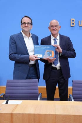 Bundespressekonferenz, Vorstellung der Studie zur Sicherheit von Kuenstlicher Intelligenz in der deutschen Wirtschaft Thomas Caspers gemeinsam mit Dr. Dirk Stenkamp und der gebundenen Studie in der Hand bei der Vorstellung der Studie zur Sicherheit von Kuenstlicher Intelligenz in der deutschen Wirtschaft. Risiken, KI-Sicherheitsvorfaelle und Schutzmaßnahmen in der Bundespressekonferenz, Berlin, 07.10.2026 Berlin Berlin Deutschland