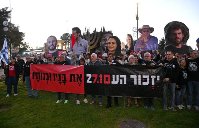 Families and supporters hold placards of faces of Israelis murdered by Hamas during a protest on the third anniversary of the deadliest day in Israel s history outside the Israeli Knesset, Parliament, in Jerusalem, on Wednesday, October 7, 2026. Demonstrators demand a state independent inquiry into the government s security failures, a request rejected by Israeli Prime Minister Benjamin Netanyahu. The banner reads The people shall remember their sons and daughters who were murdered a reference to the Yizkor prayer, with the date 27 10, the day of the upcoming general elections in Israel that are seen as a referendum on Netanyahu s power.  JER2026100704 DEBBIExHILL