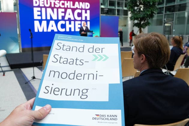 Statement des Bundesminister fuer Digtales zur Staatsmodernisierung Der Bericht in gebundener Form im Hintergrund Dr. Karsten Wildberger beim Statement zum Kabinettbeschluss des Berichts zu 1 Jahr Staatsmodernisierung, Berlin, 07.10.2026 Berlin Berlin Deutschland